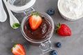 Chocolate pudding with fresh berries and whipped cream in a glass jar on a gray concrete background. Copy space Royalty Free Stock Photo