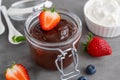 Chocolate pudding with fresh berries and whipped cream in a glass jar on a gray concrete background. Copy space Royalty Free Stock Photo