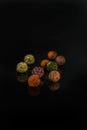 Chocolate round candies sprinkled with spices on a dark background