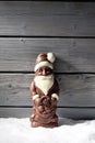 Chocolate santa claus on heap of snow against wooden background Royalty Free Stock Photo