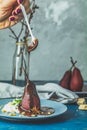 Chocolate sauce pours from a spoon on red pears in wine Royalty Free Stock Photo