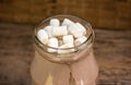 Chocolate shake marshmallows. Glass cup of cocoa with marshmallows on wooden table. Close-up