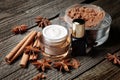 Chocolate skin treatment. Cosmetic jar with cocoa, lotion and serum, cinnamon sticks, anise.