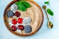 Chocolate smoothie bowl with cherry, mint and energy balls.