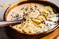 Chocolate smoothie bowl with coconut chips, banana and cocoa nibs in wooden bowl. Healthy vegetarian breakfast concept Royalty Free Stock Photo