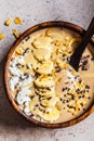 Chocolate smoothie bowl with coconut chips, banana and cocoa nibs in wooden bowl, top view. Healthy vegetarian breakfast concept Royalty Free Stock Photo