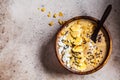 Chocolate smoothie bowl with coconut chips, banana and cocoa nibs in wooden bowl, top view. Healthy vegetarian breakfast concept Royalty Free Stock Photo