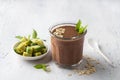 Chocolate smoothie or cocktail with frozen avocado and oatmeal garnished with mint leaves on a light blue table. vegan Royalty Free Stock Photo