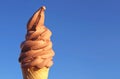 Chocolate Soft Serve Ice Cream Cone Against Sunny Vibrant Blue Sky Royalty Free Stock Photo