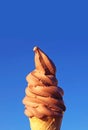 Chocolate Soft Serve Ice Cream Cone Against Vibrant Blue Sky Royalty Free Stock Photo