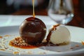 Chocolate Sphere, Passionfruit coulis cascades down, vanilla ice cream rests beside it