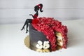 The chocolate sponge birthday cake decorated with a girl figurine and beads