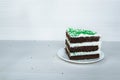 Chocolate sponge cake with buttercream interlayer located on the right. Green dusting Royalty Free Stock Photo