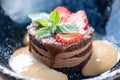 Chocolate sponge cake, with caramel, decorated with strawberries and mint leaf. Breakfast in the cafe, morning coffee Royalty Free Stock Photo