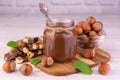 Chocolate spread with hazelnuts in a jar on a white wooden background. Royalty Free Stock Photo