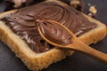 Chocolate spread on slice of bread with spoon, melted cream white bowl Royalty Free Stock Photo