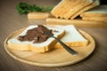 Chocolate spread on slice of bread on the wood plate. Focused on the bread with chocolate spread on it. Royalty Free Stock Photo