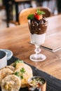 Chocolate sundae: Vanilla ice cream topping with chocolate fudge and chocolate balls with mint leaves and sliced fresh strawberry Royalty Free Stock Photo