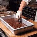 Chocolate sweets production close up, cooking, confectionery shop concept. Chief hand in white glove cutting chocolate