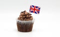 Chocolate swirl cupcake with a British Union Jack flag toothpick in it isolated on white