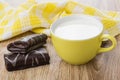 Chocolate swiss rolls, yellow napkin and cup of milk