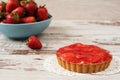 Chocolate tart, tartalette with white chocolate and mascarpone cream, fresh strawberries on top. Large blue bowl full of