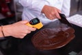 Professional chocolatier measuring chocolate temperature