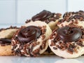 Chocolate thumbprint cookies with sprinkles and frosting piled up against a white subway tile background. Festive and delicious
