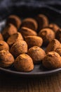 Chocolate truffles covered with cocoa powder on plate on wooden table Royalty Free Stock Photo