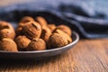 Chocolate truffles covered with cocoa powder on plate on wooden table Royalty Free Stock Photo