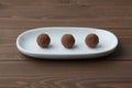 Chocolate truffles on plate on wooden table Royalty Free Stock Photo