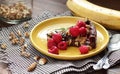 Chocolate vegan brownie cake with banana decorated with raspberry, walnut and rosemary