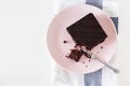 Chocolate vegan brownie cake with nuts. Pink plate. Light background. Selective focus. Royalty Free Stock Photo