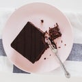 Chocolate vegan brownie cake with nuts. Pink plate. Light background. Selective focus. Top view. Square photo. Toned Royalty Free Stock Photo