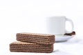 chocolate wafer cookie with cup of coffee in the background isolated on white background Royalty Free Stock Photo