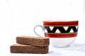 chocolate wafer cookie with cup of coffee in the background isolated on white background Royalty Free Stock Photo