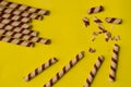 Chocolate wafer roll on a plain yellow background