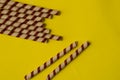 Chocolate wafer roll on a plain yellow background