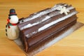 Chocolate Yule Log Cake for with a Cute Snowman Marzipan for Christmas Celebration Royalty Free Stock Photo