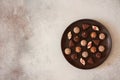 Chocolates in a clay plate on stone background