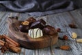 Chocolates in different shapes and colors over rustic wooden board.