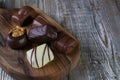 Chocolates in different shapes and colors over rustic wooden board.