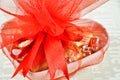 Chocolates wrapped in colored foils packed with red ribbon