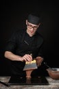 Chocolatier in black uniform in the process of making chocolates