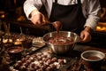 Chocolatier prepares chocolates by whisking melted chocolate with a whisk dripping downwards