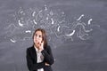 Choice concept with doubtful businesswoman on blackboard background with chalk arrows directed Royalty Free Stock Photo