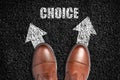 Choice concept. Men's boots on the asphalt road.Arrows in different directions.Making important decisions. Choice of