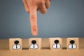 Choice of an employee leader from the crowd. the hand points to the wooden cube that symbolizes that the hand makes the choice Royalty Free Stock Photo