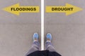 Flooding or Drought choice, text on asphalt ground, feet and shoes on floor