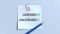 Choice between licensed and unlicensed options on a checklist with a checkmark and Royalty Free Stock Photo